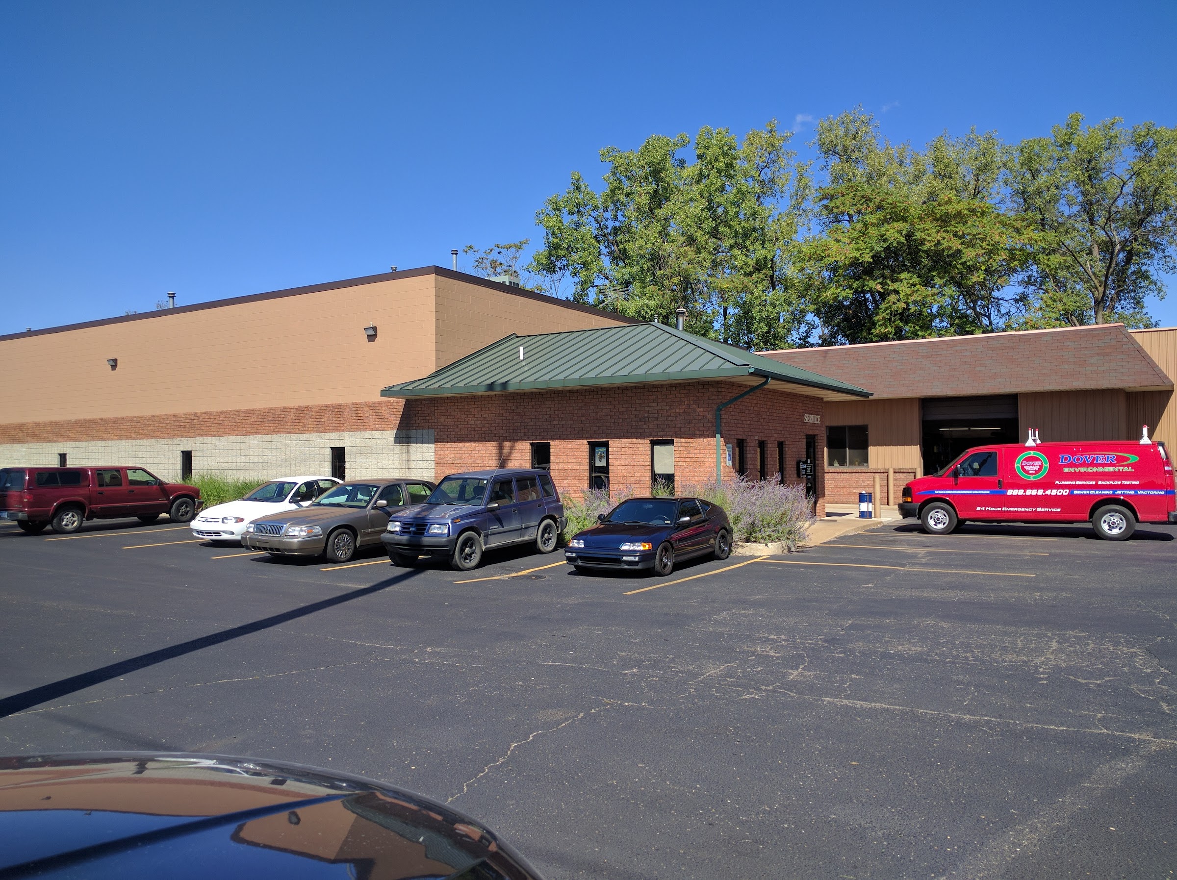 Parker Brake & Alignment on Burton Street — brick shop with the green canopy, an open service bay, and the red Parker service van out front